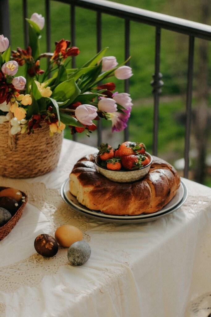 Lush spring brunch scene with Easter coloured eggs, easter bread, and fresh tulip bouquet.