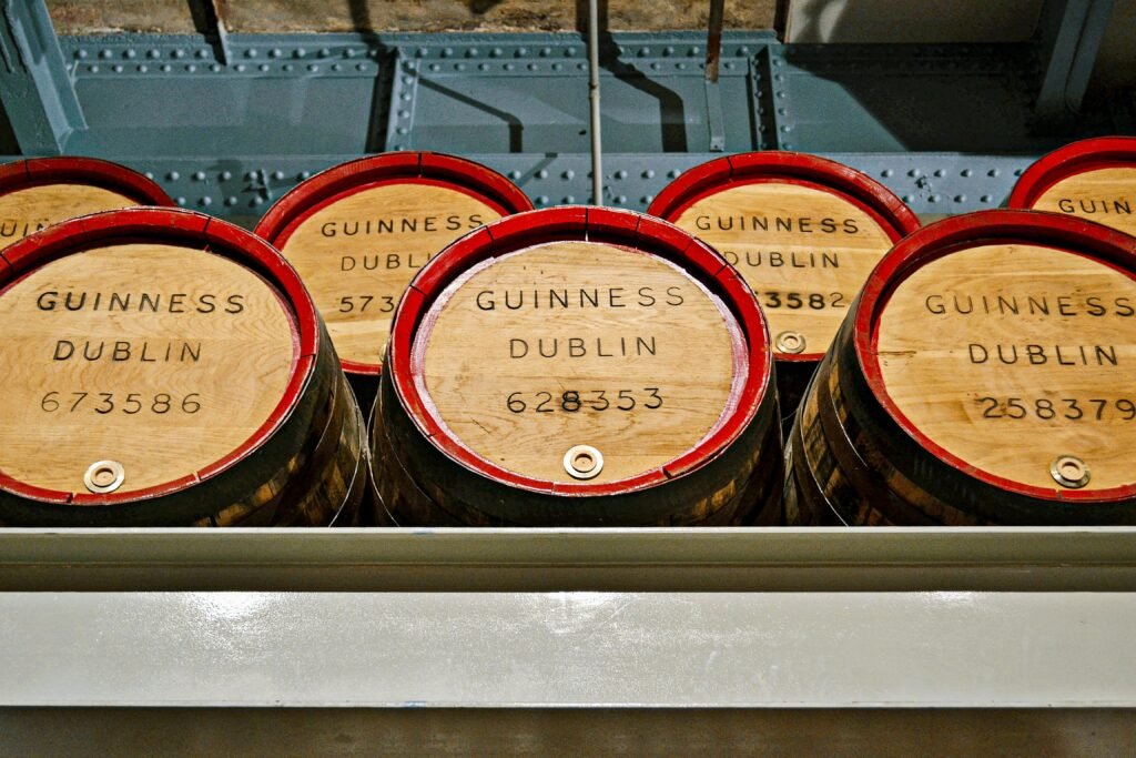 Wooden barrels labeled 'Guinness Dublin' in a museum setting showcasing Irish brewing history.