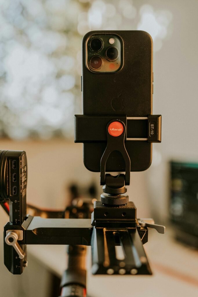 A close-up of a smartphone mounted on a tripod, ready for filming or photographing.